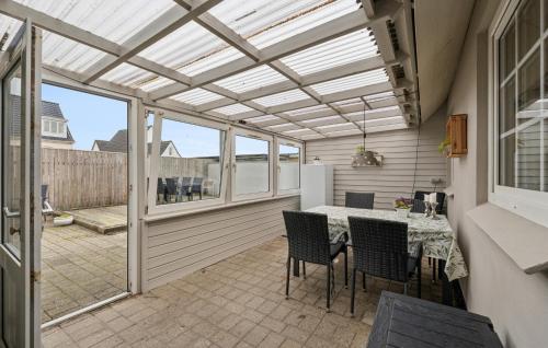 a conservatory with a table and chairs on a patio at Nice Home In Thyborøn With Wifi in Thyborøn