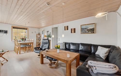 a living room with a black leather couch and a wooden ceiling at Nice Home In Thyborøn With Wifi in Thyborøn