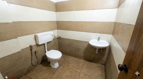 a bathroom with a toilet and a sink at SAIS LINE Residency in Kozhikode