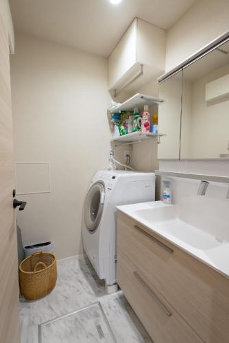 a laundry room with a washing machine and a sink at ローズパーク十番館 in Narashino