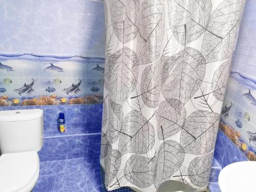 een badkamer met een douchegordijn en een toilet bij Qokhna Samarqand in Samarkand