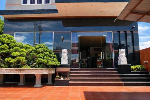 Un edificio con puertas de cristal y escaleras al frente. en Vườn Dừa Cam Bình 2, en Vĩnh Thạnh