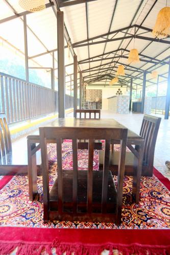 a wooden table and chairs on top of a rug at The SKYi County Dapoli in Dapoli