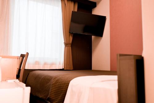 En eller flere senge i et værelse på Arigato Stay Kanazawa Ekimae