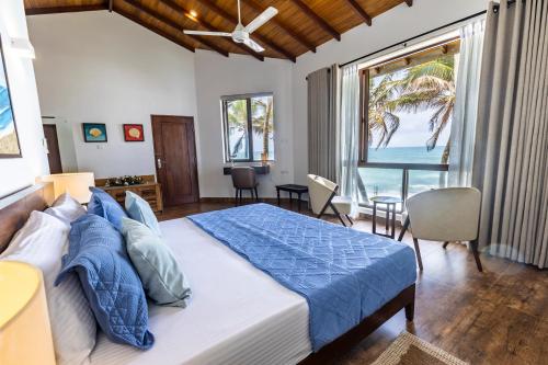 Un dormitorio con una cama con vista al mar. en The Beach Home, en Galle