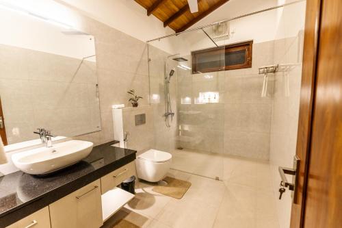Un baño con lavabo, inodoro y ducha. en The Beach Home, en Galle
