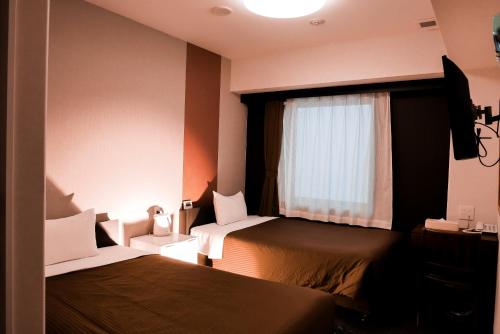 En eller flere senge i et værelse på Arigato Stay Kanazawa Ekimae