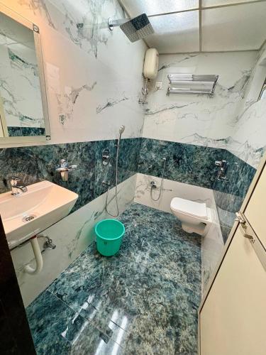 a bathroom with marble walls and a sink and a toilet at Hotel Broadway Colaba in Mumbai