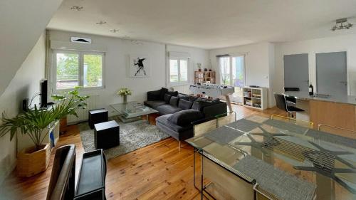Large duplex with terrace في ستراسبورغ: غرفة معيشة بها أريكة وطاولة