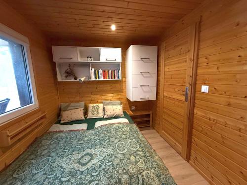 een kleine kamer met een bed in een houten hut bij Ubytování Na pasece in Benešov