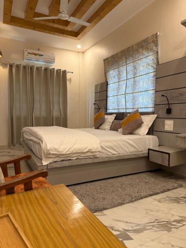 a bedroom with a large bed and a window at Nature's Nest Resort in Dehradun Airport
