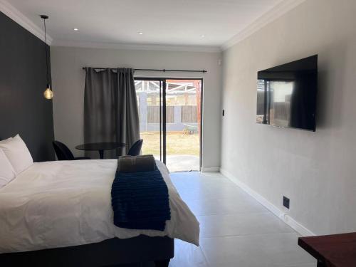 奥兰治蒙德Unit 8 Dinas Accommodation Oranjemund的一间卧室，里面有一张床、一张桌子和一扇窗户