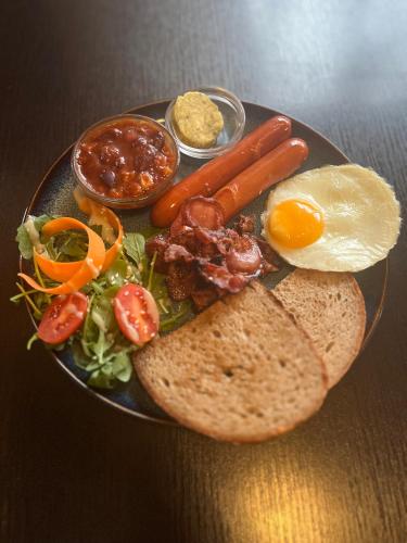 Un plato de comida con salchichas, verduras y pan. en Parkhotel Terezín, en Terezín
