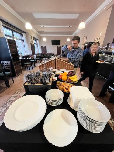 un grupo de personas de pie alrededor de una mesa con platos en ella en Parkhotel Terezín, en Terezín