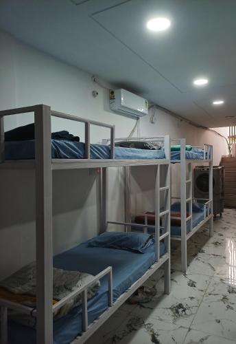 a room with three bunk beds in a room at Leesha Tower - Dormitory in Jhānsi