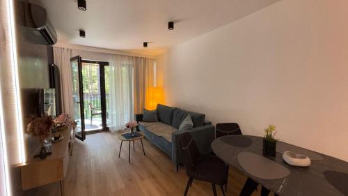 een woonkamer met een bank en een tafel bij Sea&Forest Międzyzdroje Amber Suite in Międzyzdroje