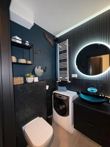 a bathroom with a sink and a washing machine at Międzyzdroje Sea & Forest Amber and Ocean Suites in Międzyzdroje