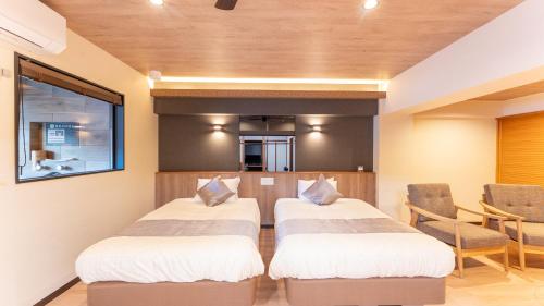 two beds in a room with a table and chairs at LiVEMAX Resort Echigo Yuzawa in Yuzawa