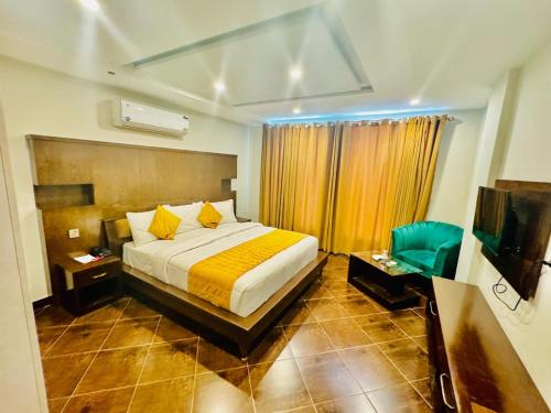 a hotel room with a bed and a television at Bling International Hotel Multan in Multan