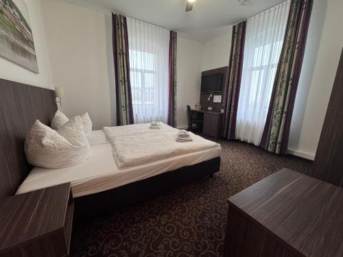 a hotel room with a bed and two windows at Pension Luft in Dresden
