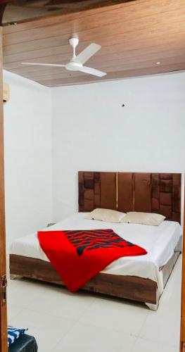 een bed met een rode deken erop bij Omega guest houses in Amritsar