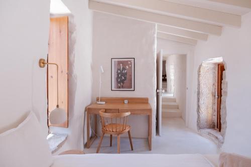 een kamer met een houten bureau en een stoel bij Casa d'Aire in Porto de Mós