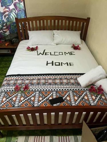 a bed with a welcome home sign on it at Beachside Haven Homestay in Yarawa Island