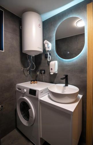 a bathroom with a washing machine and a sink at Homeland Nest in Žabljak