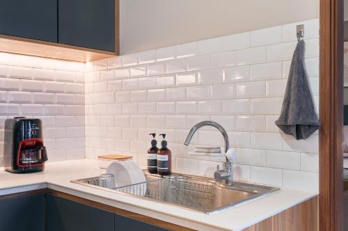 バンドンにあるSudirman Suites by Eazystayのシンクとカウンタートップのあるキッチン
