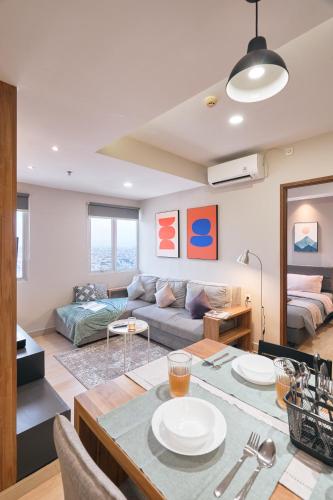 a living room with a couch and a table at Sudirman Suites by Eazystay in Bandung