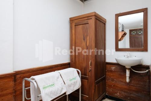 a bathroom with a sink and a mirror at The Soemarsono Hotel near Ambarrukmo Plaza Mall RedPartner in Yogyakarta