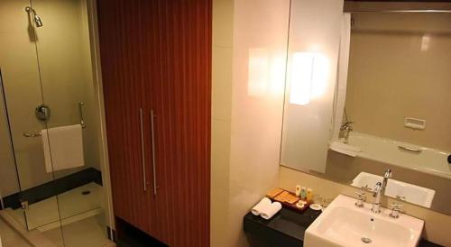 un baño con lavabo y espejo en Hotel Pangeran, en Pekanbaru