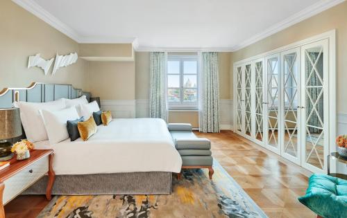 ein Schlafzimmer mit einem Bett und einer Couch in der Unterkunft Mandarin Oriental, Munich in München