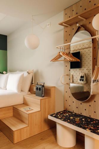 a bedroom with a bed and a room with a shelf at Hobo Oslo in Oslo