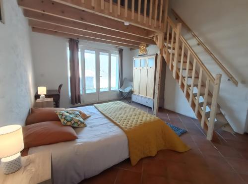 een slaapkamer met een bed en een trap bij Charmante Maison De Village 60 M² in Mollans-sur-Ouvèze
