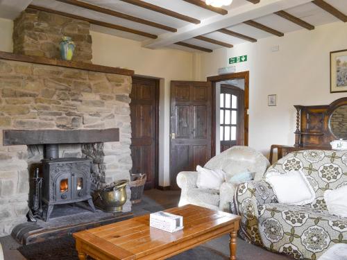 a living room with a stone fireplace and a couch at Grove Sprightly Barn in Craven Arms
