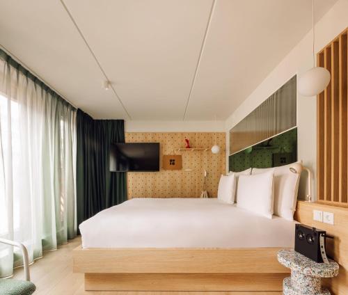 a bedroom with a white bed and a tv at Hobo Oslo in Oslo
