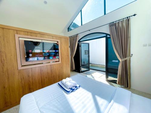 ein Schlafzimmer mit einem Bett und einem großen Fenster in der Unterkunft Oasis Montana Jogja in Ngemplak