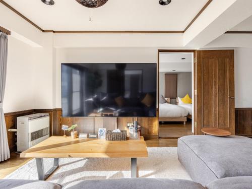 a living room with a large flat screen tv at LIT’S INN Sapporo in Sapporo