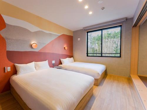 a hotel room with two beds and a window at Rakuten STAY VILLA Fuji Kawaguchiko Forest 2LDK with sauna and terrace in Fujikawaguchiko