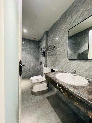 a bathroom with a sink and a toilet and a mirror at Khách sạn Sole'a VĨNH YÊN in Vĩnh Phúc