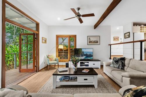 a living room with a couch and a tv at Magnolia Cottage in Cooroy