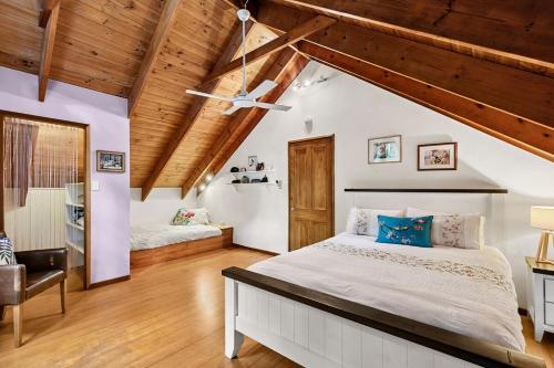 a bedroom with two beds and a wooden ceiling at Magnolia Cottage in Cooroy