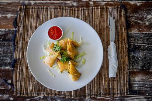 レンボンガン島にあるD'Gume Villas Lembonganのテーブルの上に食べ物が載った白い皿