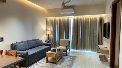 a living room with a blue couch and a table at Nature's Nest Resort in Dehradun Airport