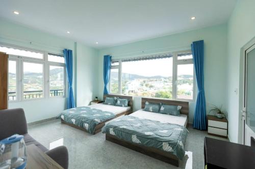 1 Schlafzimmer mit 2 Betten und blauen Vorhängen in der Unterkunft Dalat House in Vũng Tàu