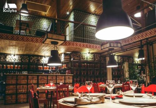 a restaurant with tables and red chairs and lights at Zakarpatska Kolyba in Odesa