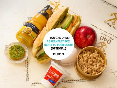 eine Frühstücksbox mit einem Sandwich, einem Apfel und einer Flasche Senf in der Unterkunft Numa Hamburg St Georg in Hamburg