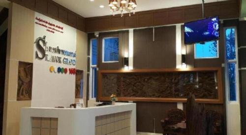a lobby with a reception desk and a television at Silayok Grand Hotel in Tak