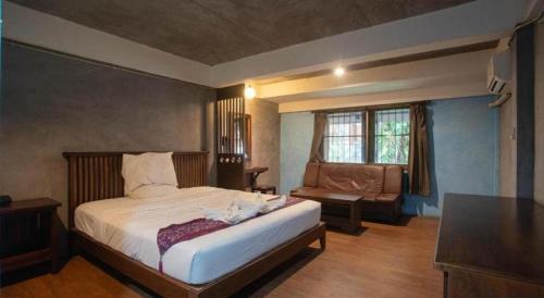 ein Schlafzimmer mit einem großen Bett und einer Couch in der Unterkunft P1 House in Sathani Phitsanulok
